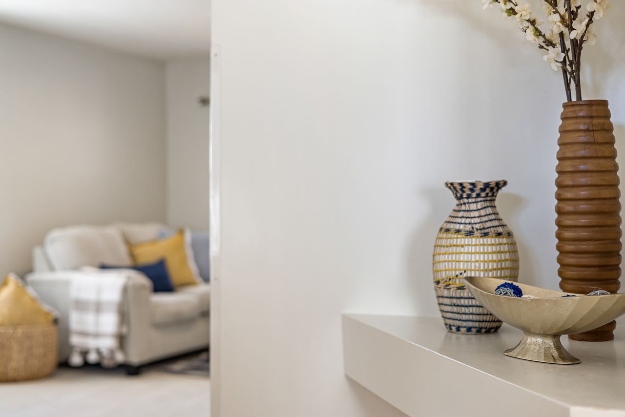 Stylish home interior featuring decorative vases on a shelf with a cozy couch in the background.