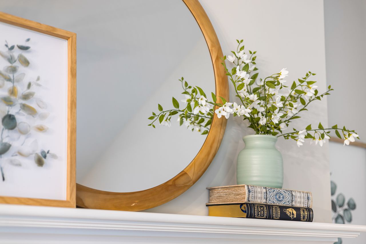 A stylish arrangement featuring a floral vase, mirror, and framed art, perfect for modern interiors.